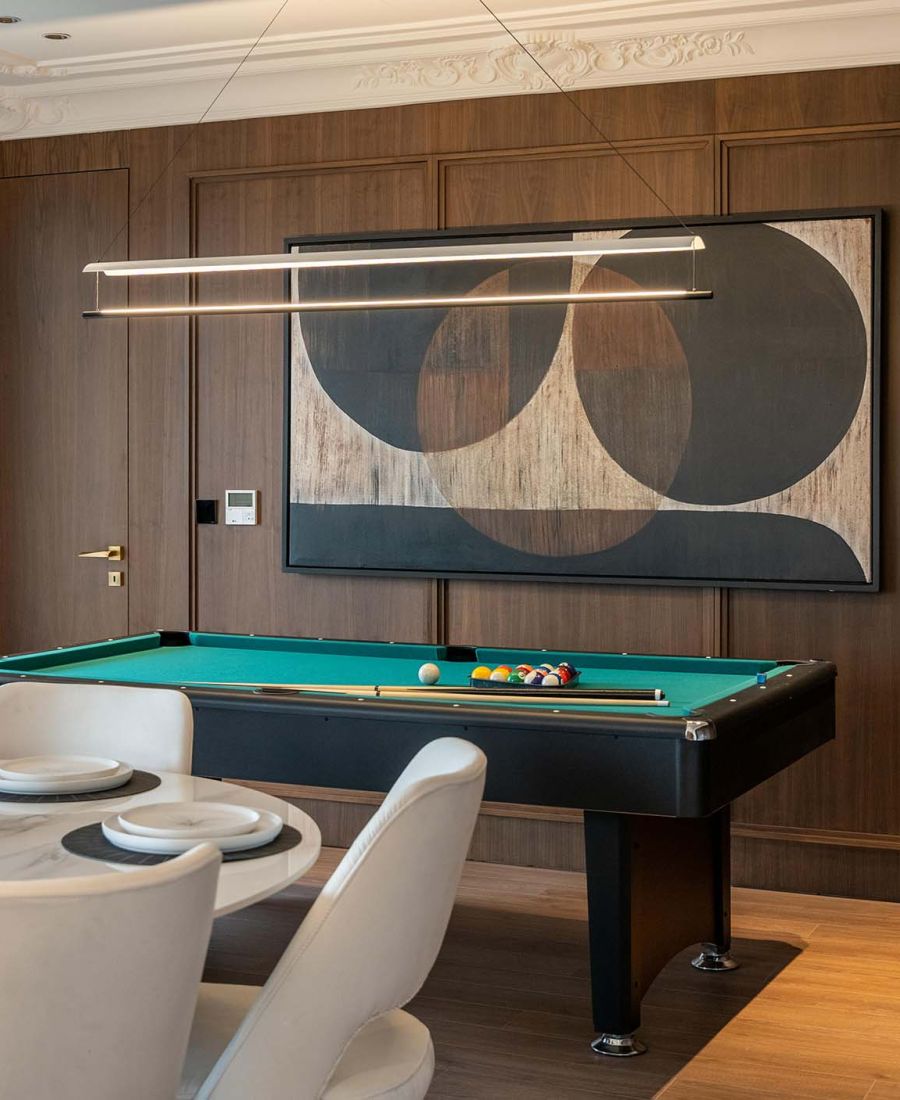 game room with modern light fixtures and wooden paneled walls